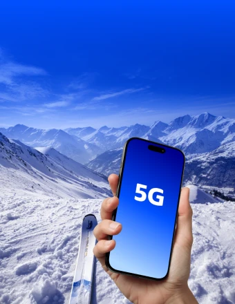 Telefon v ruce s 5G připojením na zasněžených horách v zahraničí