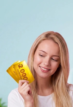 Žena držící dvě zlaté dárkové karty s hodnotou 2000 Kč